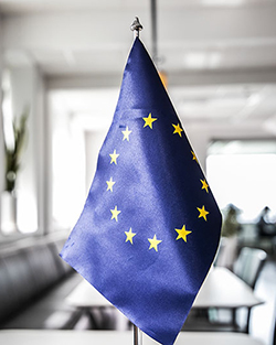 Bild på en blå EU-flagga. Den innehåller en cirkel med gula stjärnor.